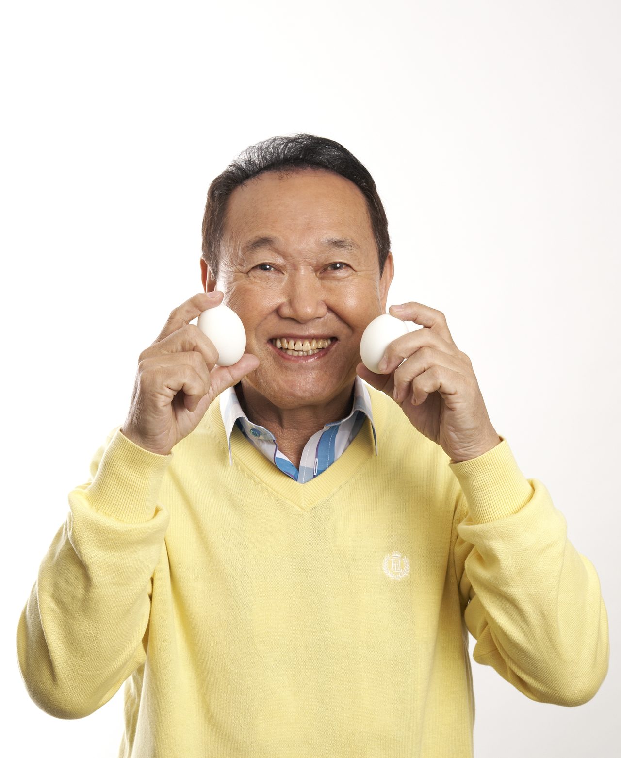卵を手に笑顔を見せる板東英二さん