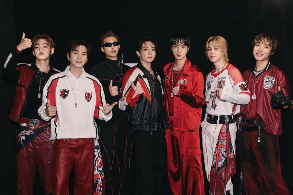 BTSメンバーがサッカーボールを持ちレッドデビル風衣装でポーズを取る様子