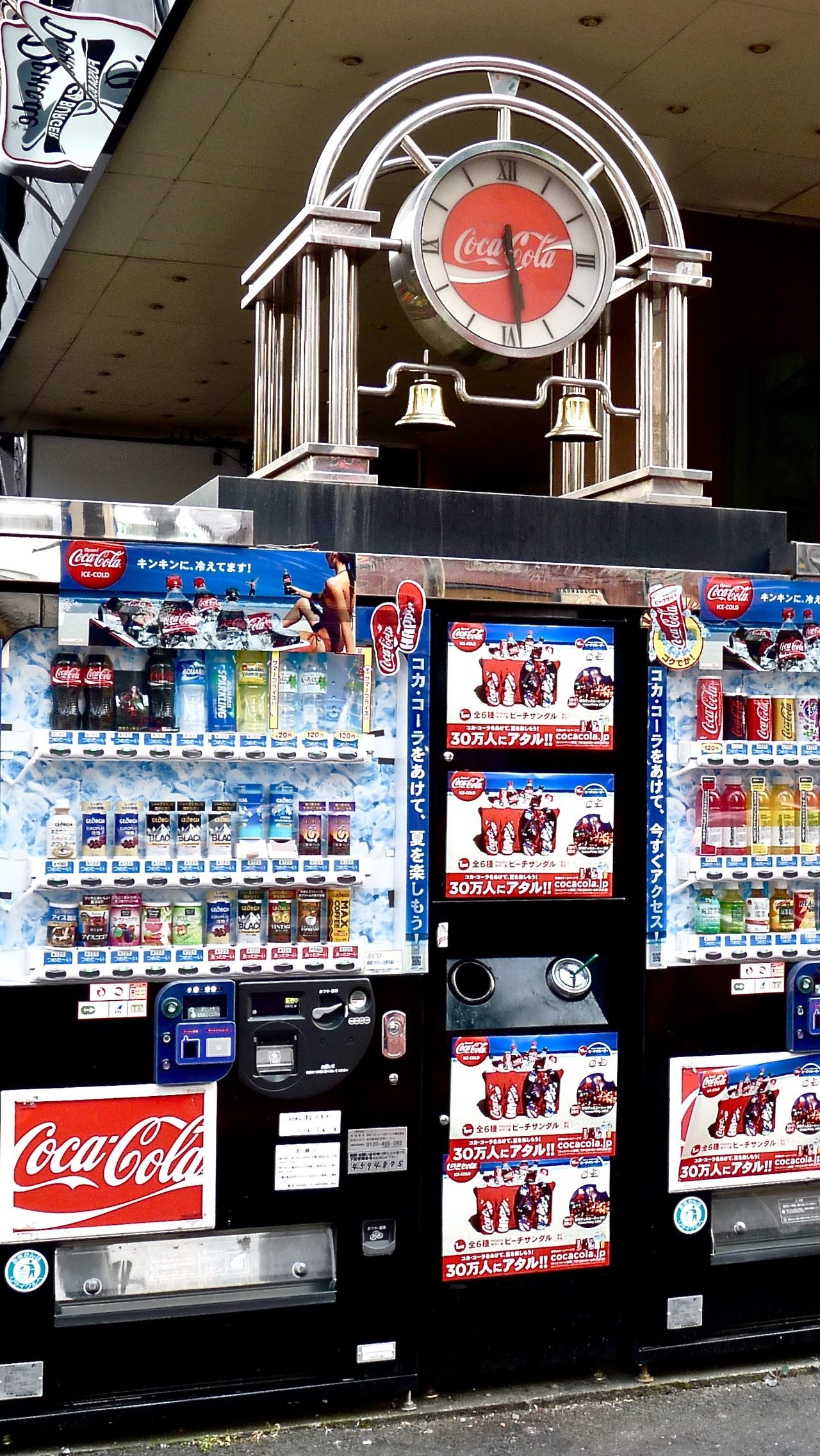 コカ・コーラのロゴが入った自動販売機の看板