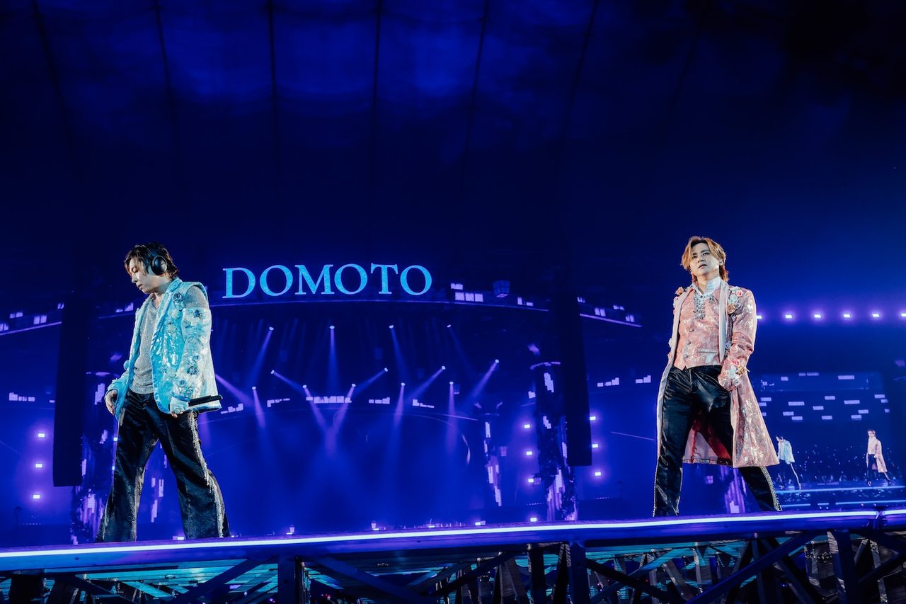 DOMOTOのロゴが映るステージで堂本光一と堂本剛の2人が並んで歩く様子