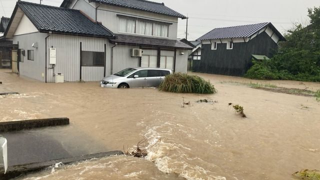 濁流に浸かった住宅と自家用車