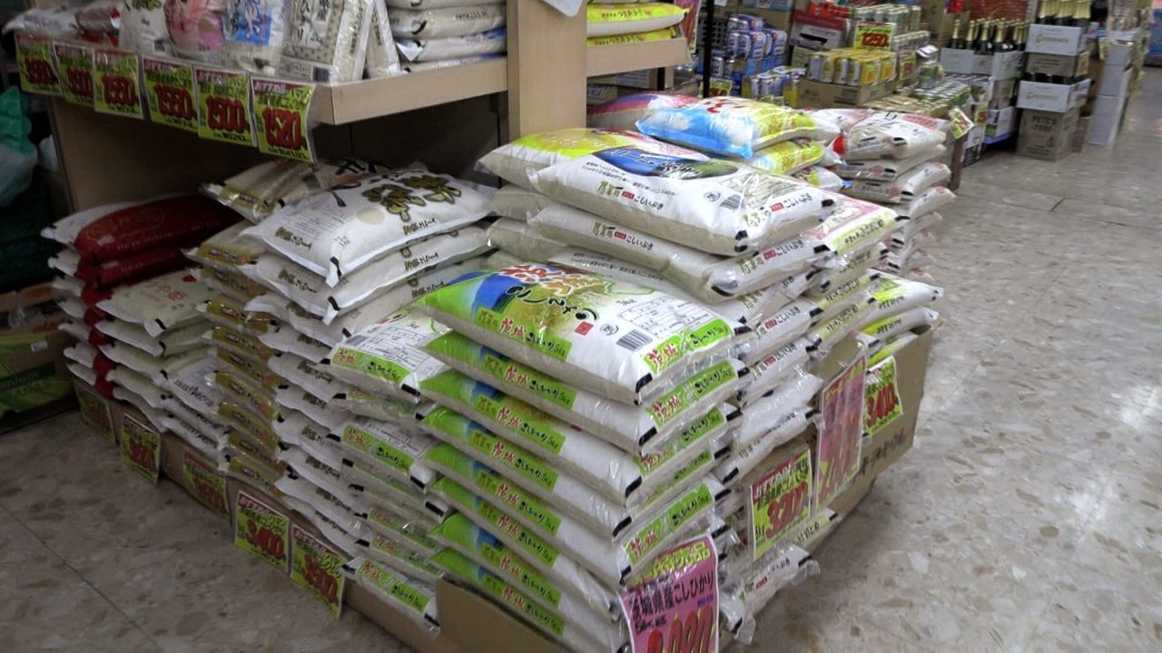スーパーの店頭に積まれたコメの袋 5kg3198円まで値下がり