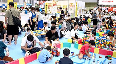 TOKYOおもちゃショーのレゴ体験コーナーで遊ぶ親子連れ