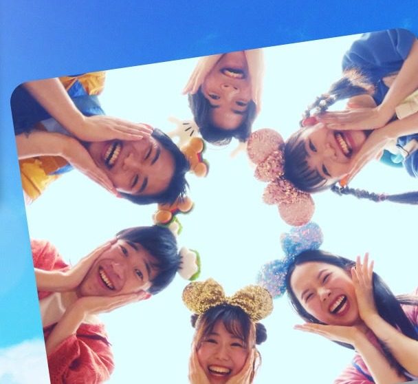 ディズニーの仲間と記念撮影する学生