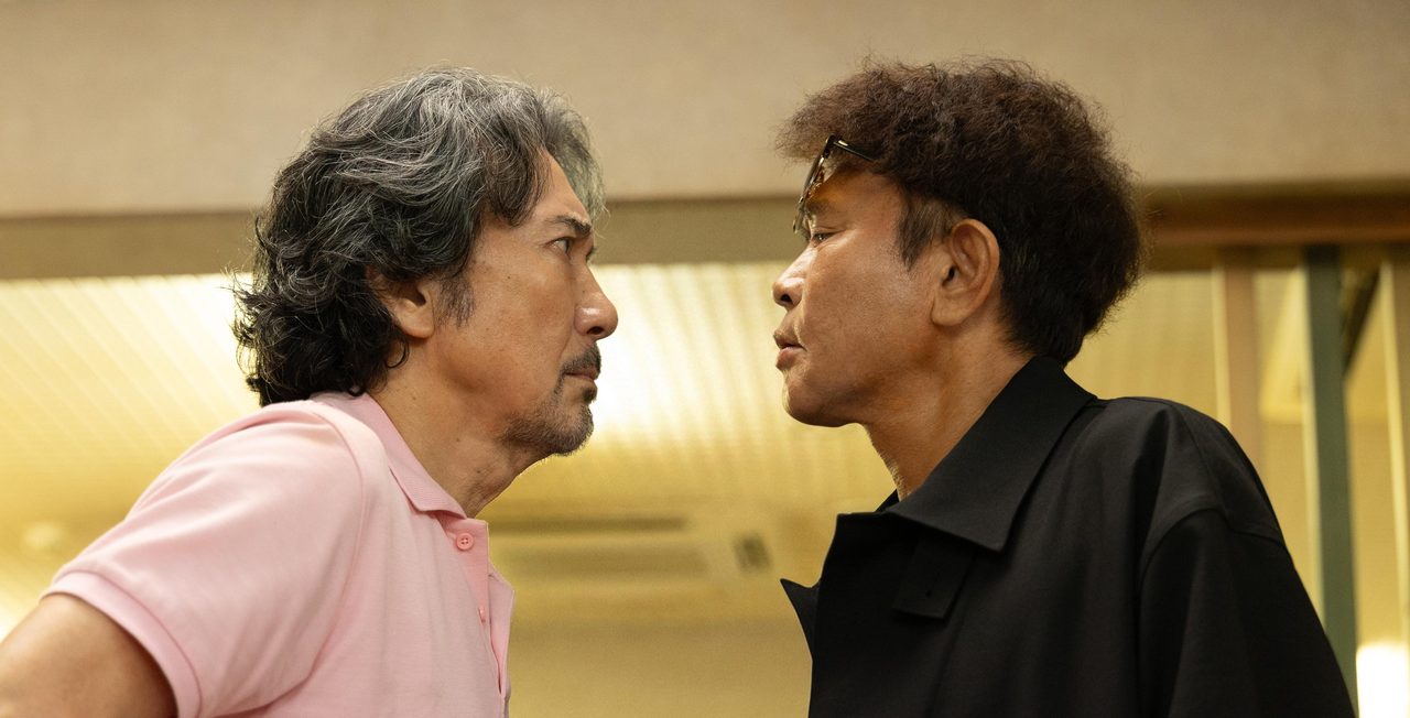 役所広司演じる高瀬川玄と濵田雅功演じる壬生大也が向き合う場面写真