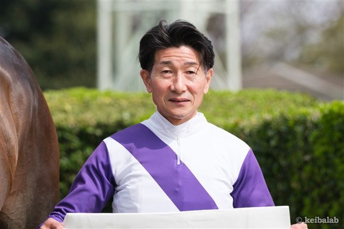 柴田善臣騎手が競走馬とともにパドックに立つ様子