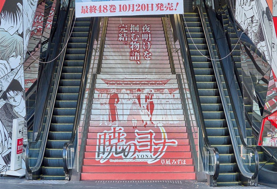 表参道オモカドの階段に貼られた暁のヨナの広告。最終48巻10月20日発売の文字が見える
