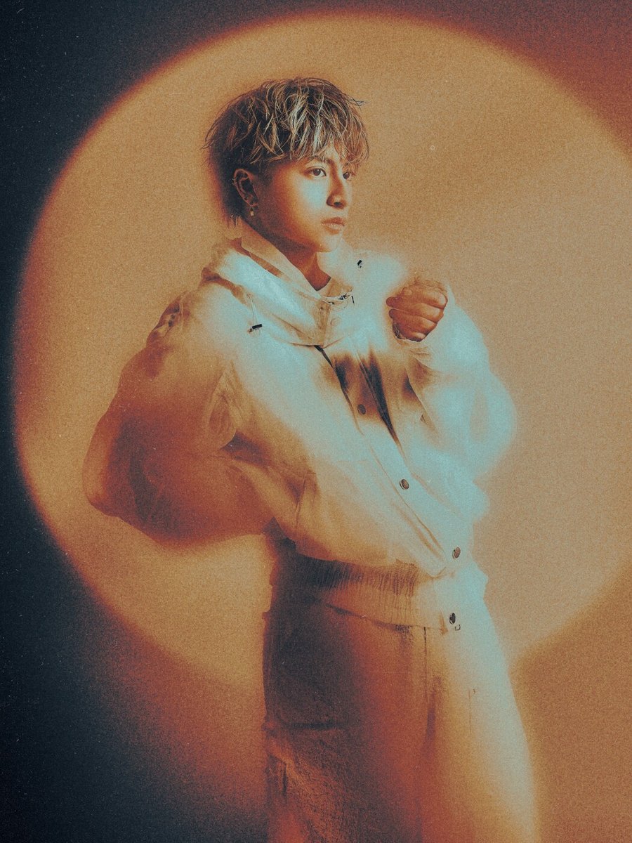白濱亜嵐のアーティスト写真 オレンジの光を背にした白いジャケット姿