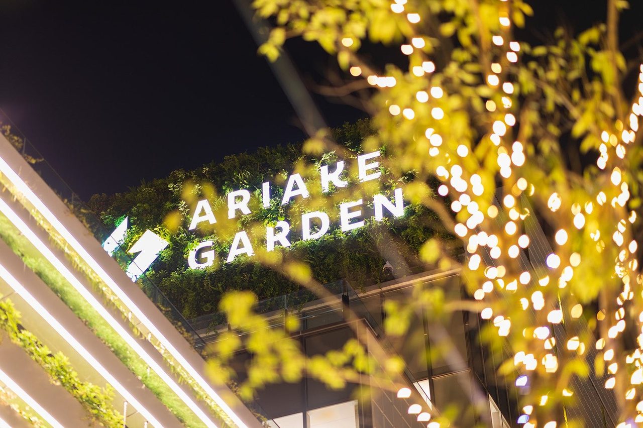 有明ガーデンのロゴ看板と、木々に巻かれた電球の光