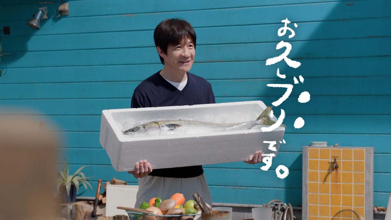 晴れ風新CMで発泡スチロールの箱に入った大きなブリを抱える内村光良 画面には「お久ブリです。」の手書き文字