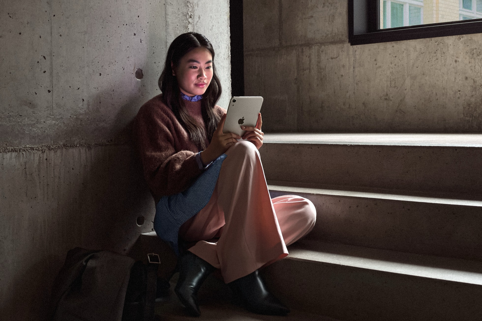 階段に座ってiPad miniを使う女性・8.5インチの持ち運びやすいタブレット