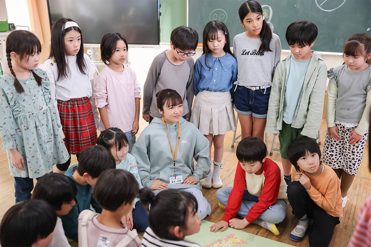 第3話の場面写真 児童たちに囲まれて座る教師のいろは