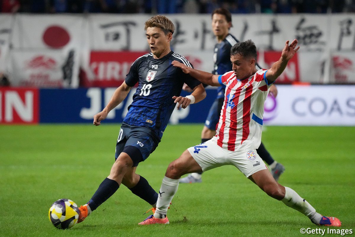 日本代表とパラグアイ代表の選手がボールを競り合うシーン
