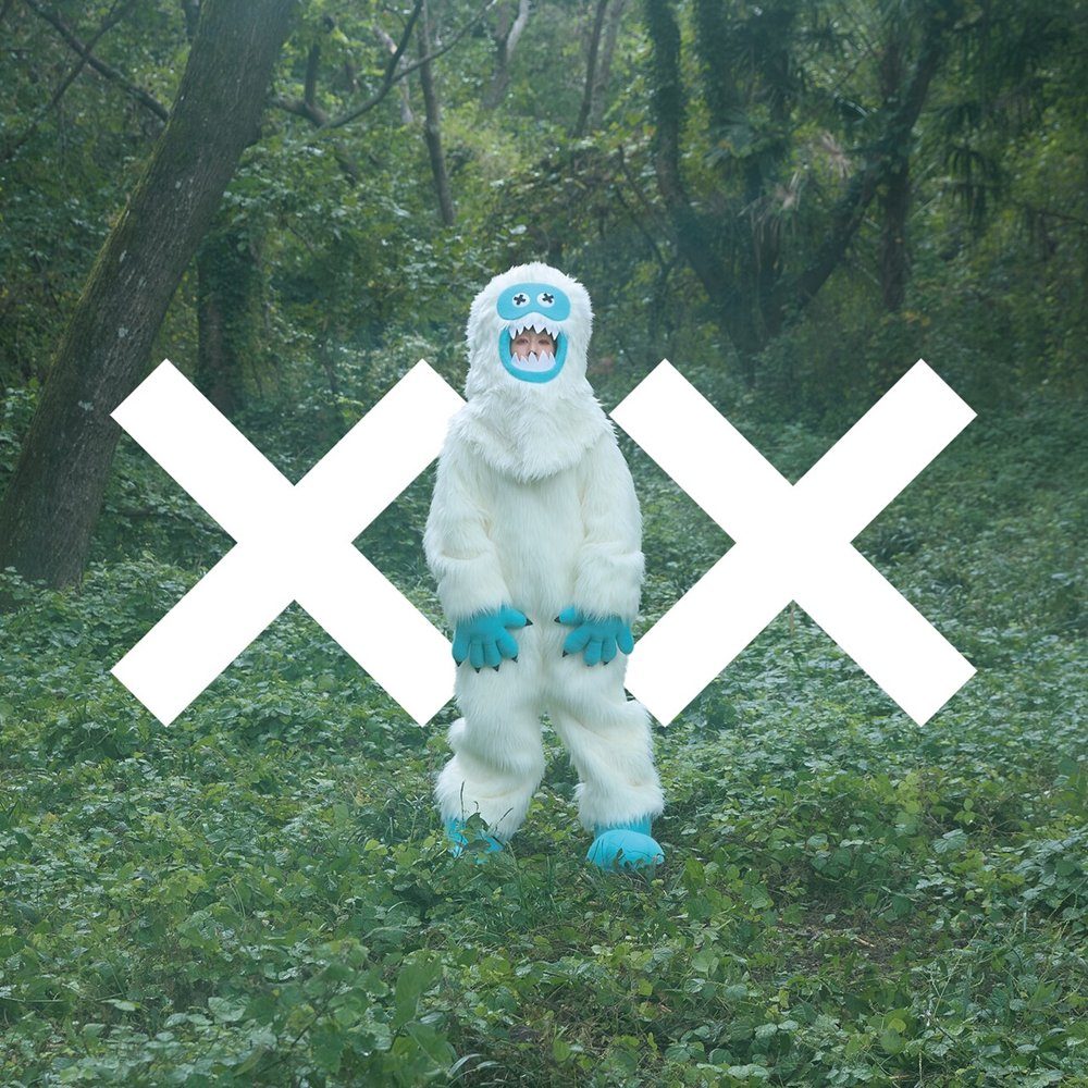 木村カエラ「XX」通常盤ジャケット。白い毛皮の着ぐるみ姿の人物が緑の森に立ち、白いXXの文字が重なる