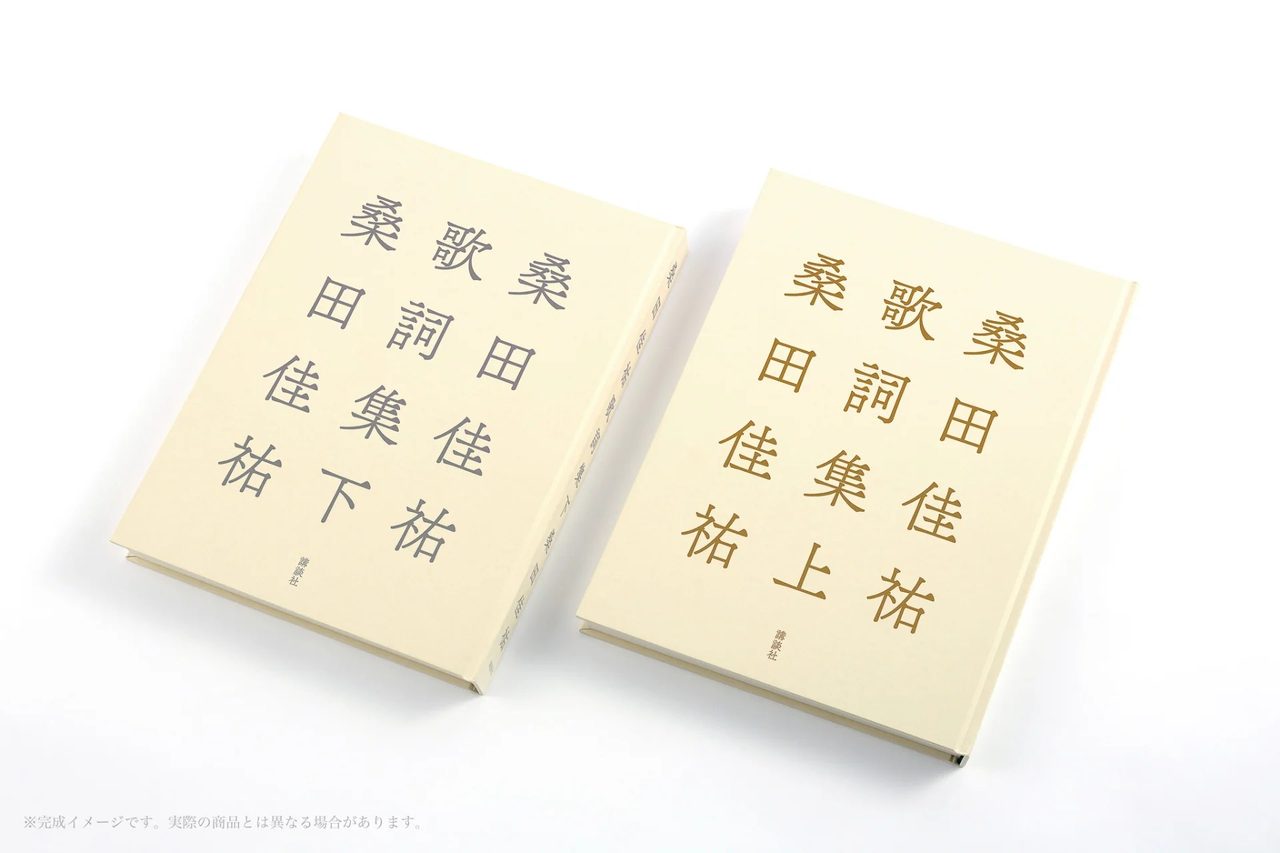 桑田佳祐歌詞集の上巻と下巻を並べたところ。上巻は金色、下巻は灰色の文字
