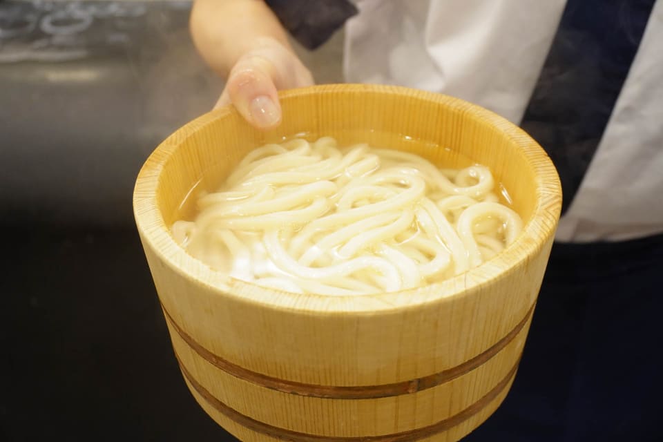 丸亀製麺 釜揚げうどんを桶で提供する様子
