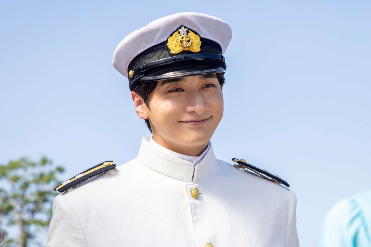 続編のキャスト、小関裕太演じる深見龍之介が海軍の白い制服姿で笑う場面