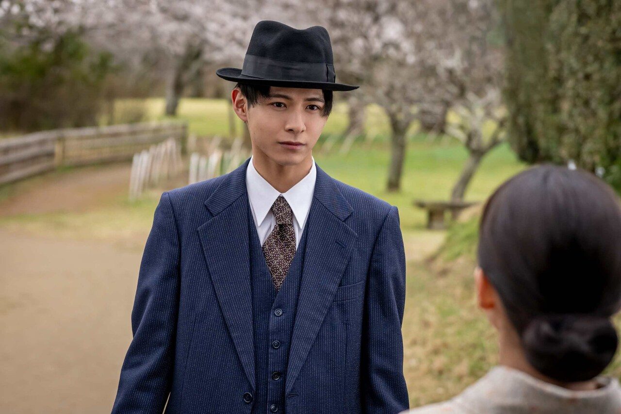 続編のキャスト、小宮璃央演じるなつ美の幼なじみ・瀬田準太郞が帽子とスーツ姿で歩く場面