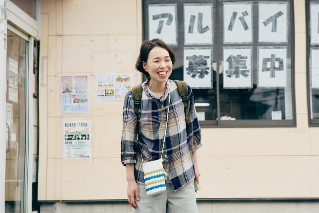 映画『見上げてごらん』場面写真 求人の貼り紙の前に立つ人物