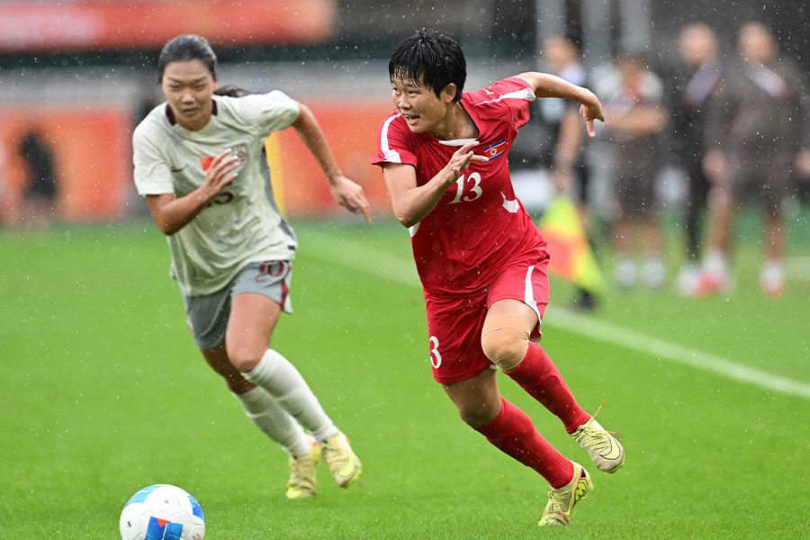 中国戦で相手DFと競り合いながらボールを運ぶ北朝鮮女子代表の13番