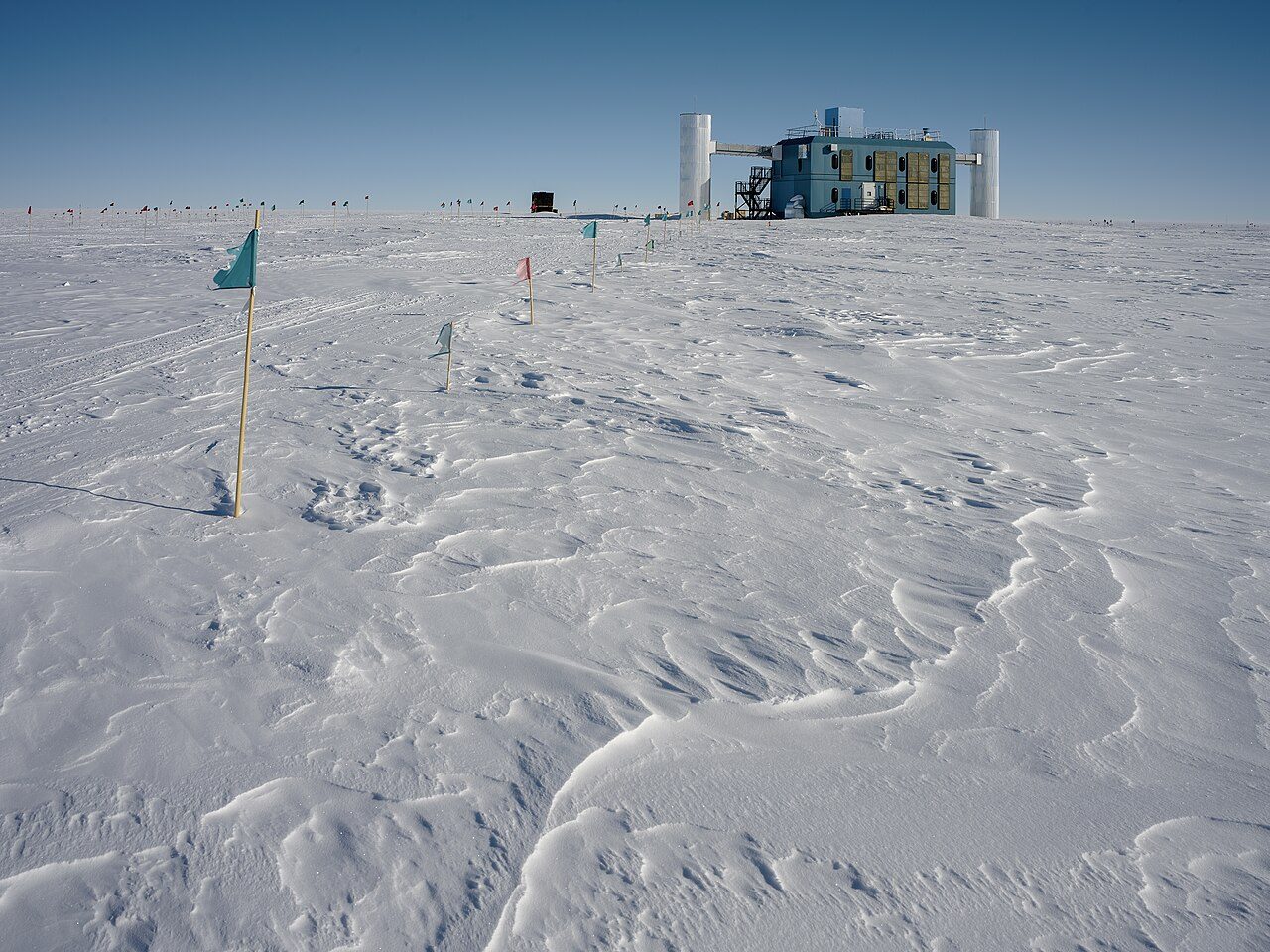 雪原の先に建つ青い実験棟、南極点のアイスキューブ研究所