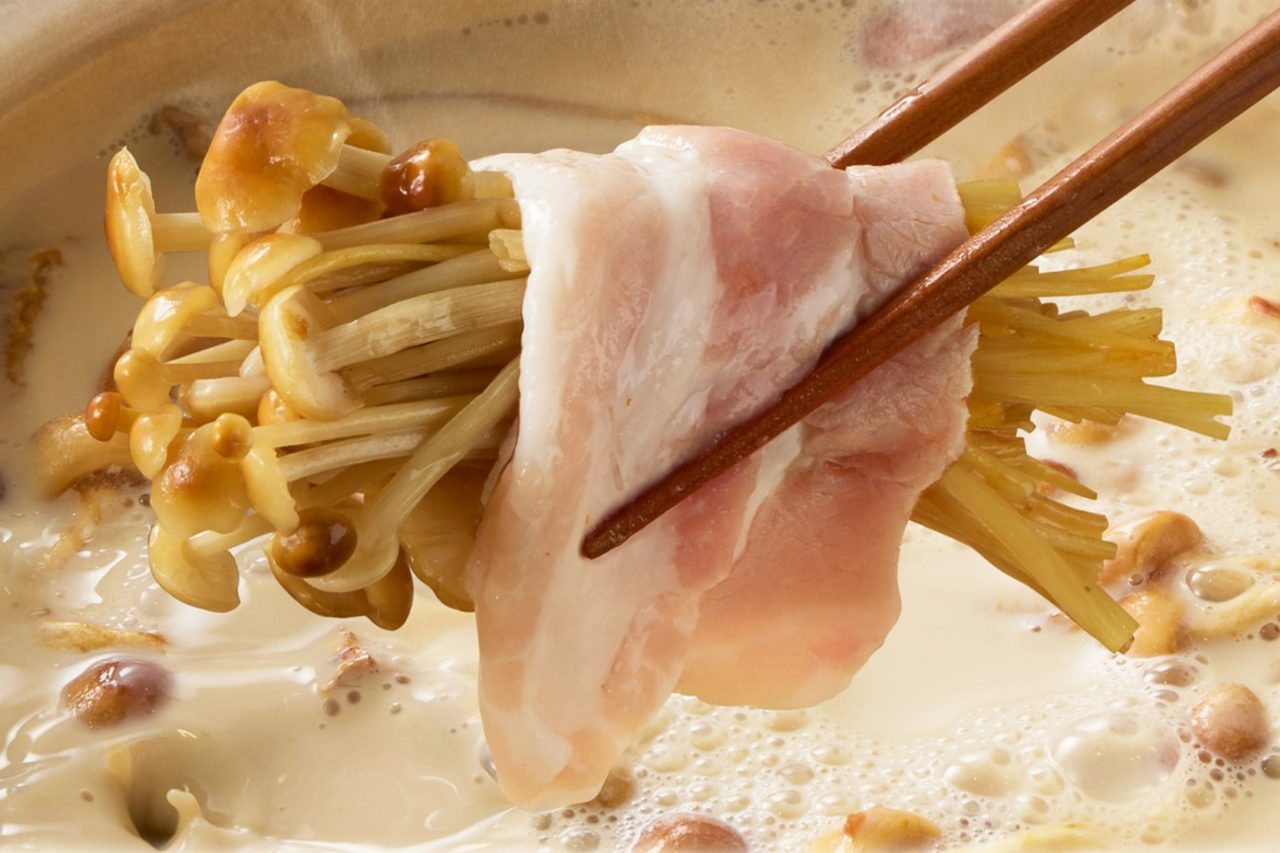豆乳ポルチーニ鍋のだしに豚肉とえのきをくぐらせたしゃぶしゃぶのアップ