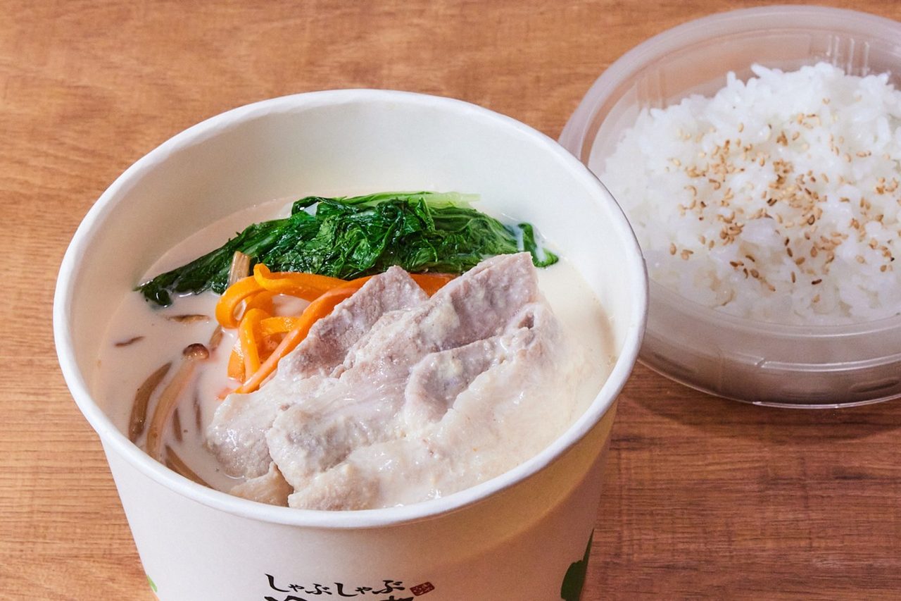 豆乳ポルチーニ鍋の食べるスープ。豚肉と野菜が入ったカップとご飯の容器
