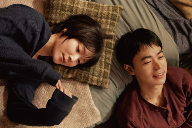 映画『男ともだち』場面写真 並んで横になり笑顔を見せる男女
