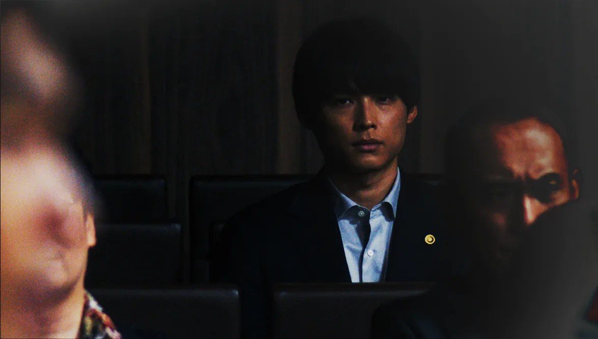 映画『九条の大罪』場面写真 法廷の傍聴席に座る烏丸役の松村北斗