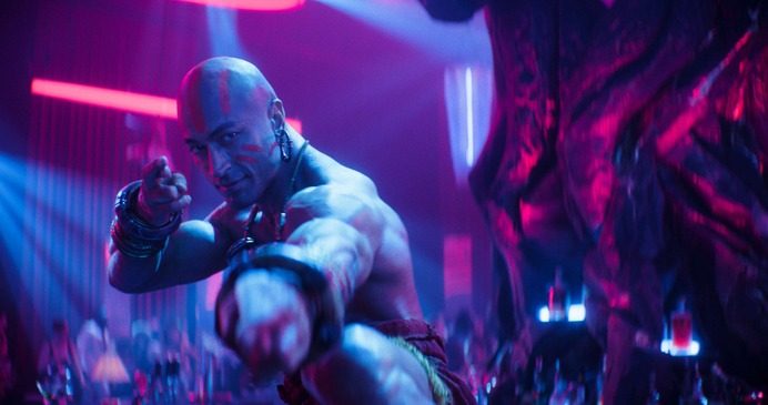 ストリートファイター実写映画の劇中カット 青紫の照明の中で構える格闘家