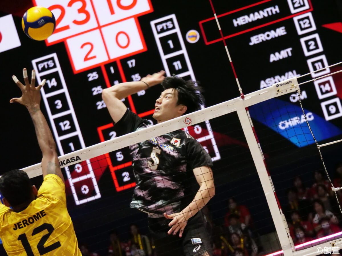 ネット際でスパイクを打つバレーボール男子日本代表の選手