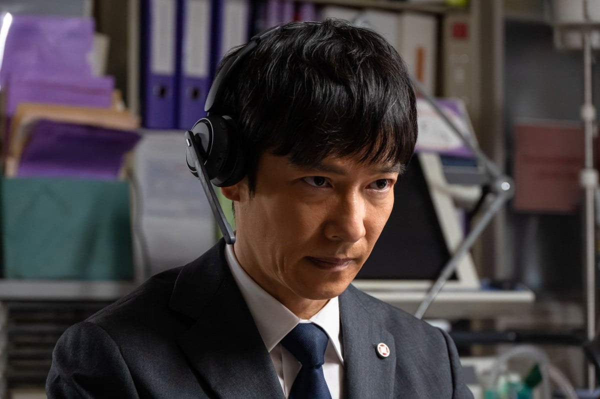 VIVANT第2シリーズ ヘッドホンをつけて真剣な表情でモニターを見つめるスーツ姿の男性