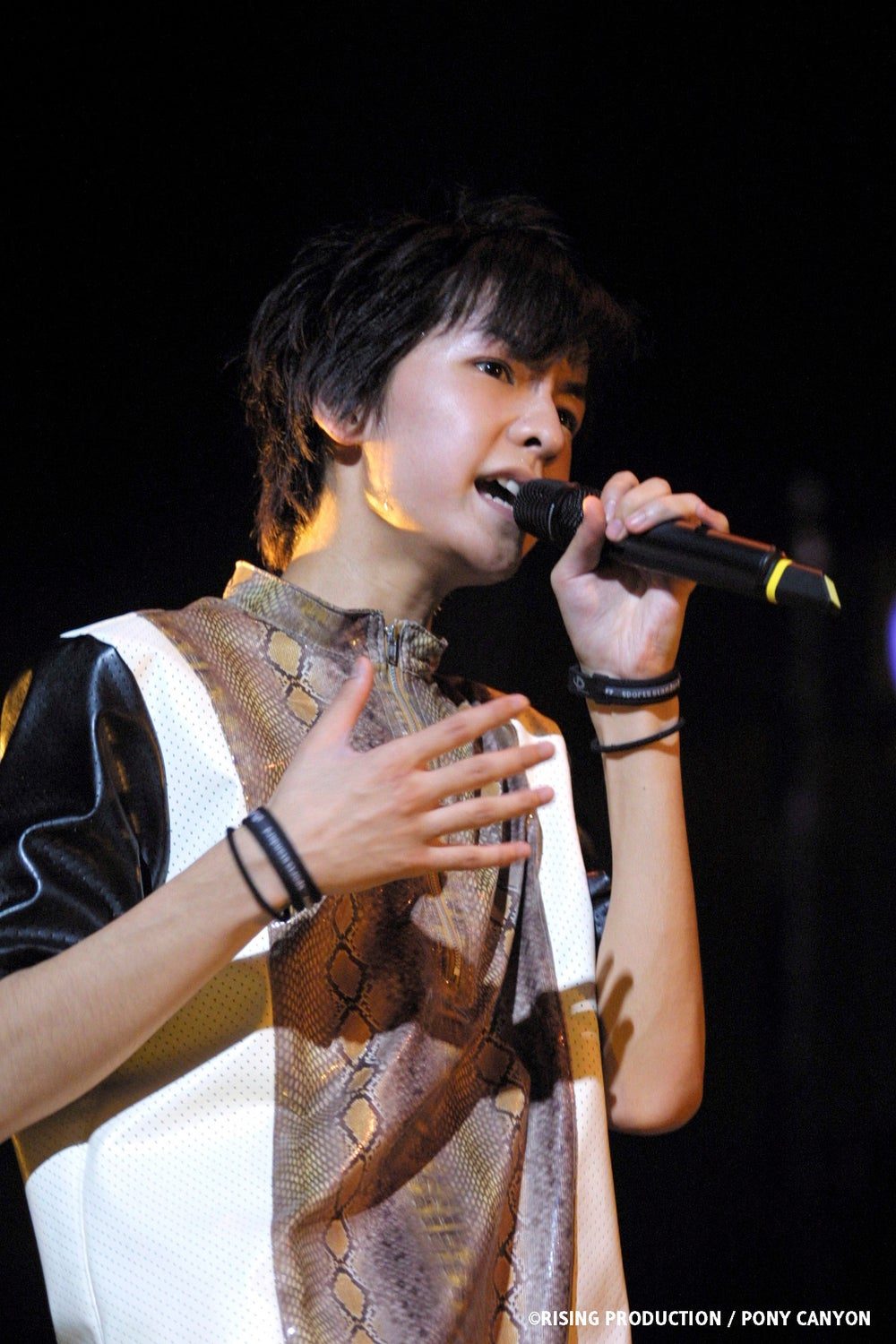 w-inds.の過去のライブでマイクを持って歌うメンバーのステージ写真